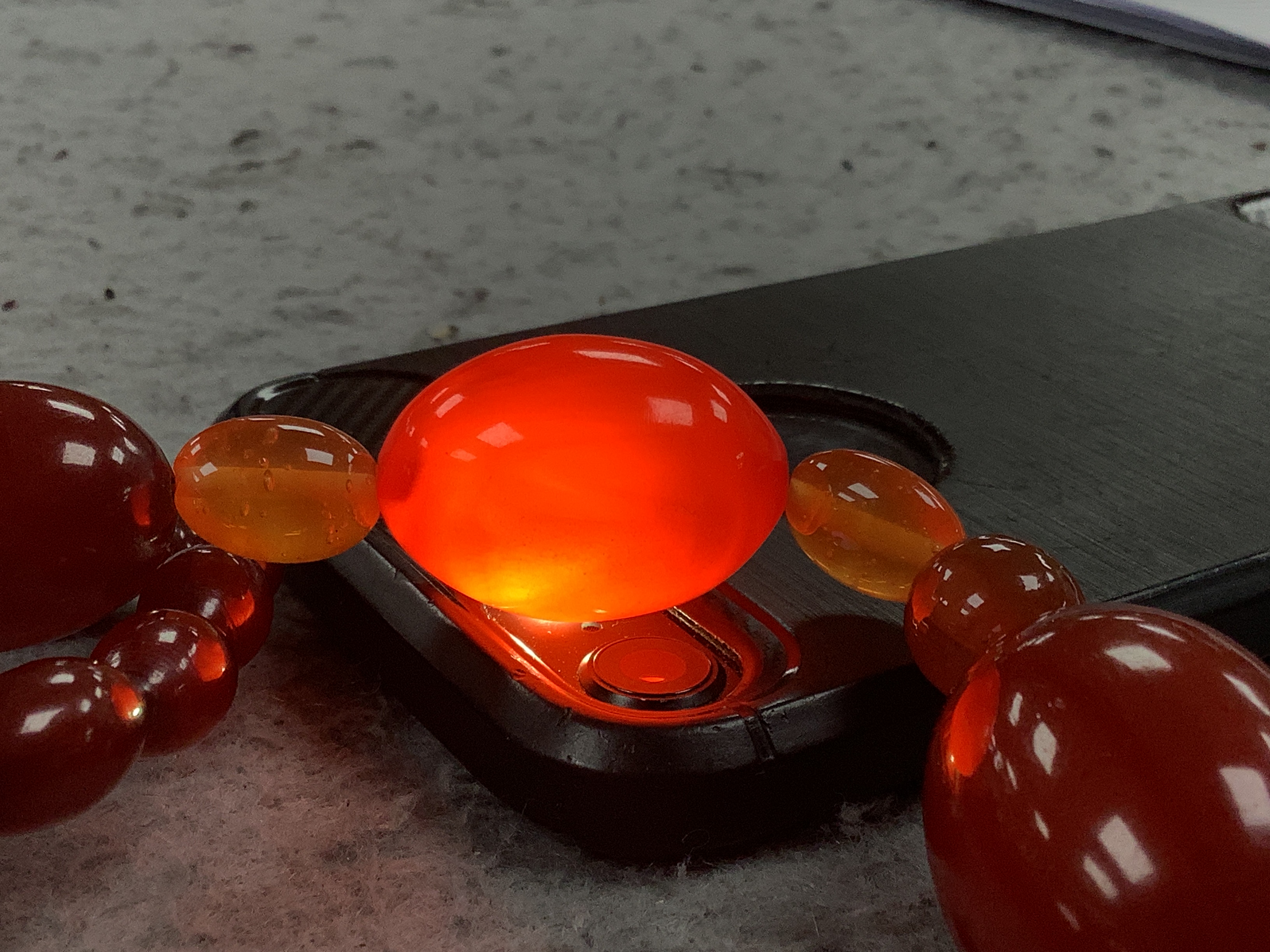 A single strand graduated simulated cherry amber bead necklace, with four simulated orange amber beads, 66cm, gross weight 84 grams.